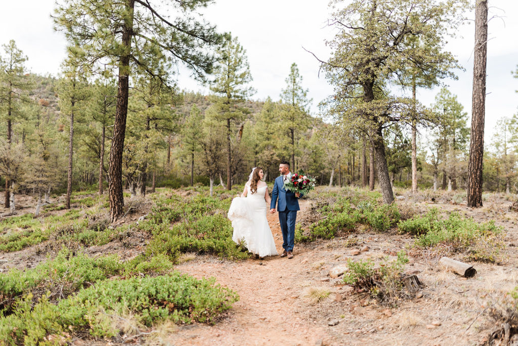 bride and groom walking in the pine trees at their Cabins on Strawberry Hill Wedding