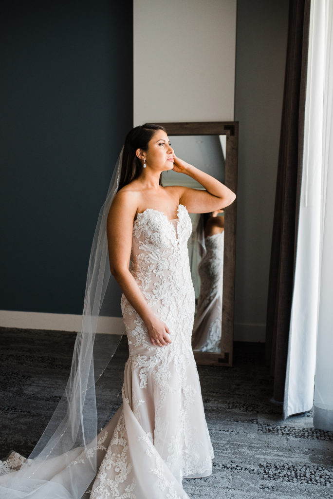 Bride looking out window before ceremony 