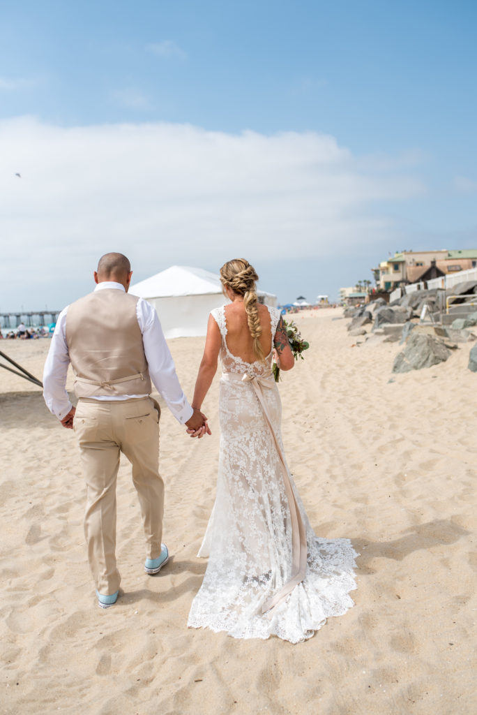 beach wedding bride and groom walking away california 