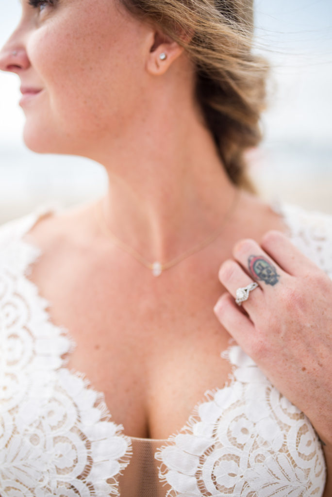 california dream beach wedding bride close up of ring and necklace 
