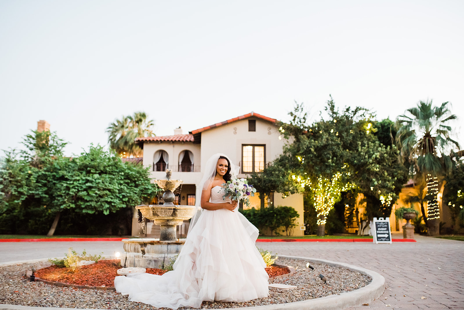 bride standing in front of the fountain at the Secret Garden Phoenix wedding venue
