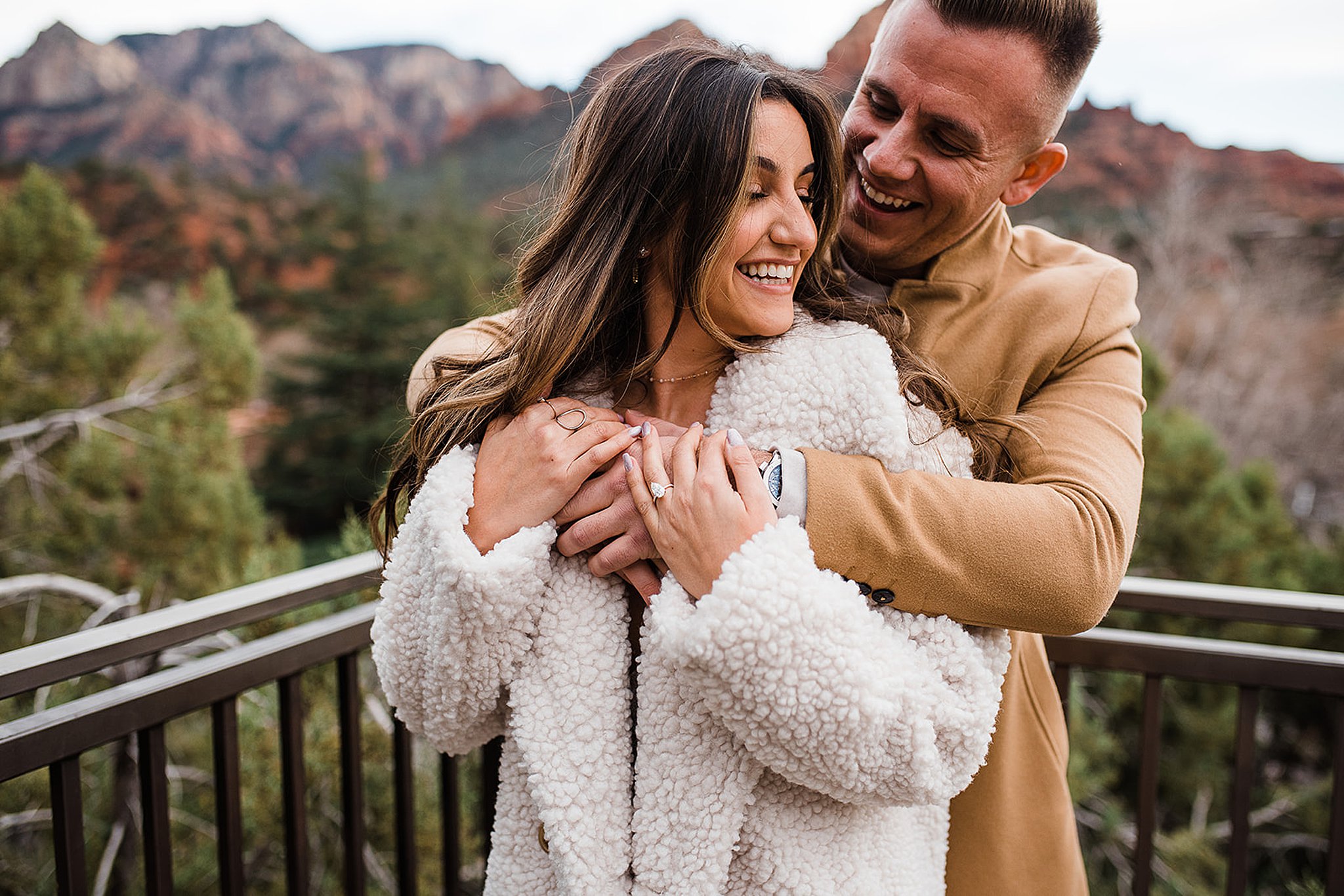 man hugging his fiance from behind at a L'Auberge De Sedona proposal
