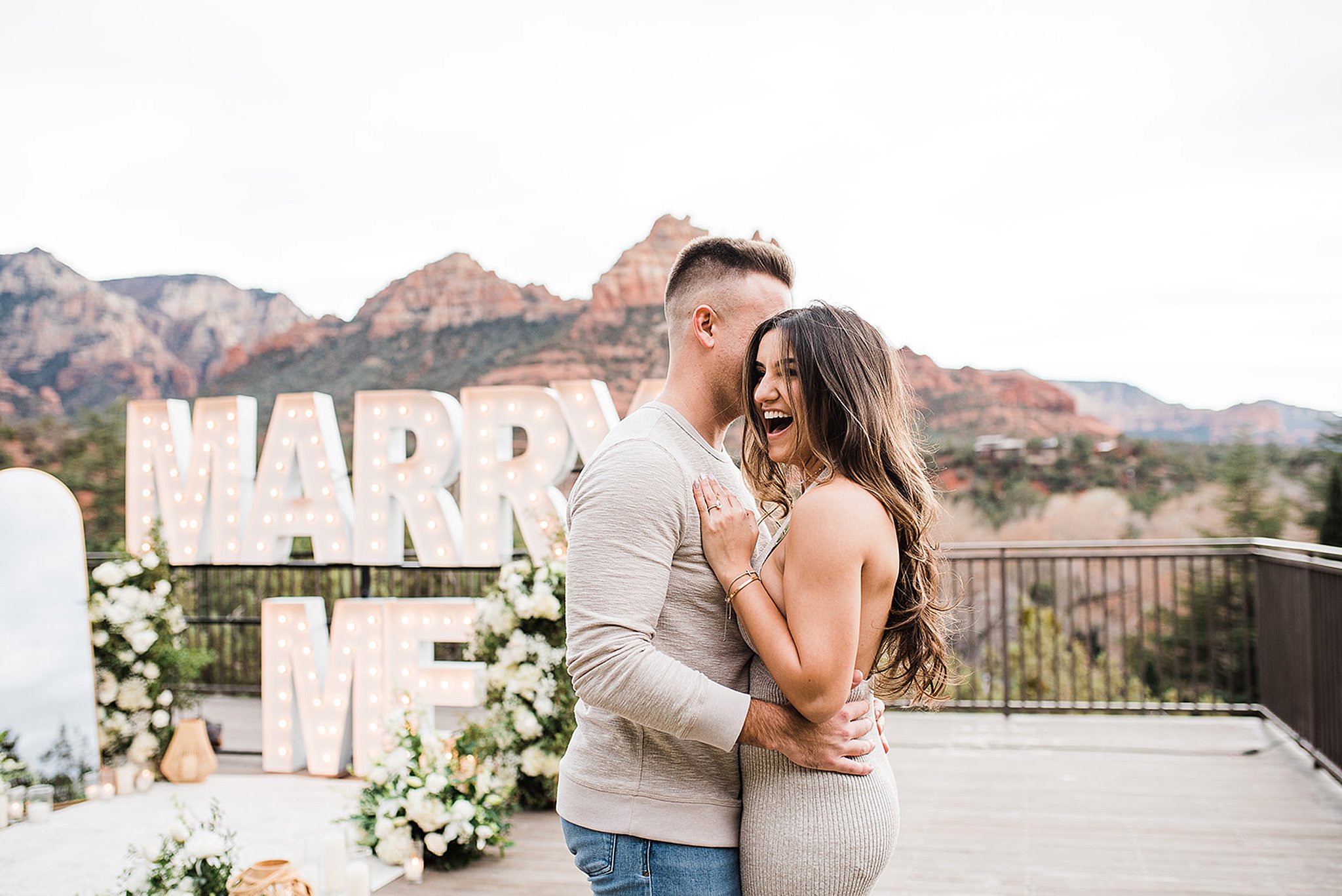 couple standing in front of a marry me sign at a L’Auberge de Sedona Wedding proposal