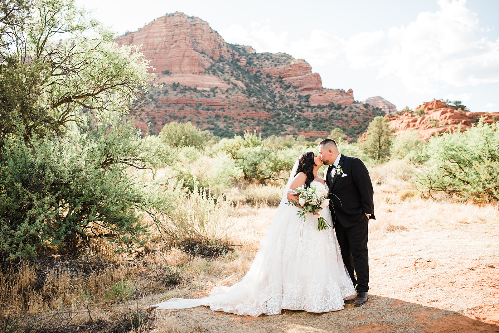 bride and groom kiss in the desert destination at oak creek wedding