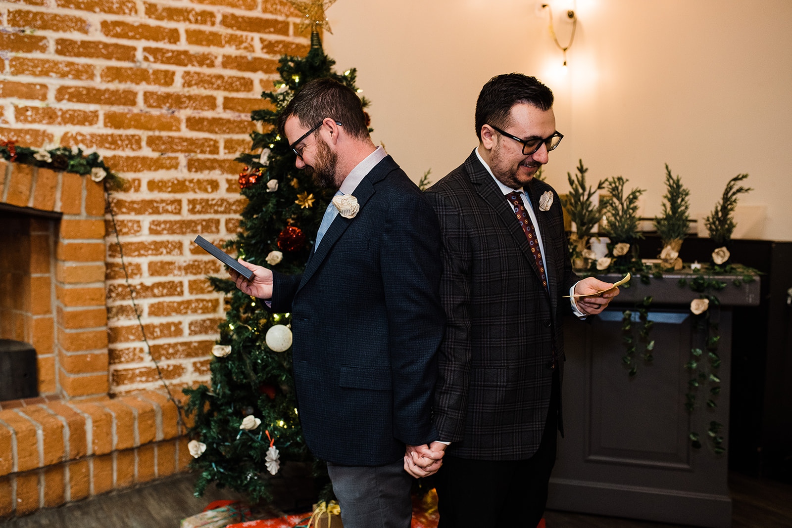 Newlyweds hold hands and exchange gifts in front of a christmas tree at The Newton Phoenix