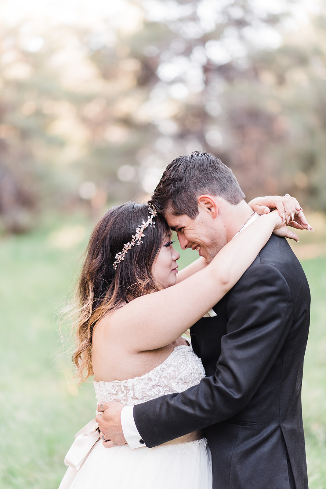 Newlyweds embrace with foreheads touching in a grassy field at Creekside Inn Sedona Wedding
